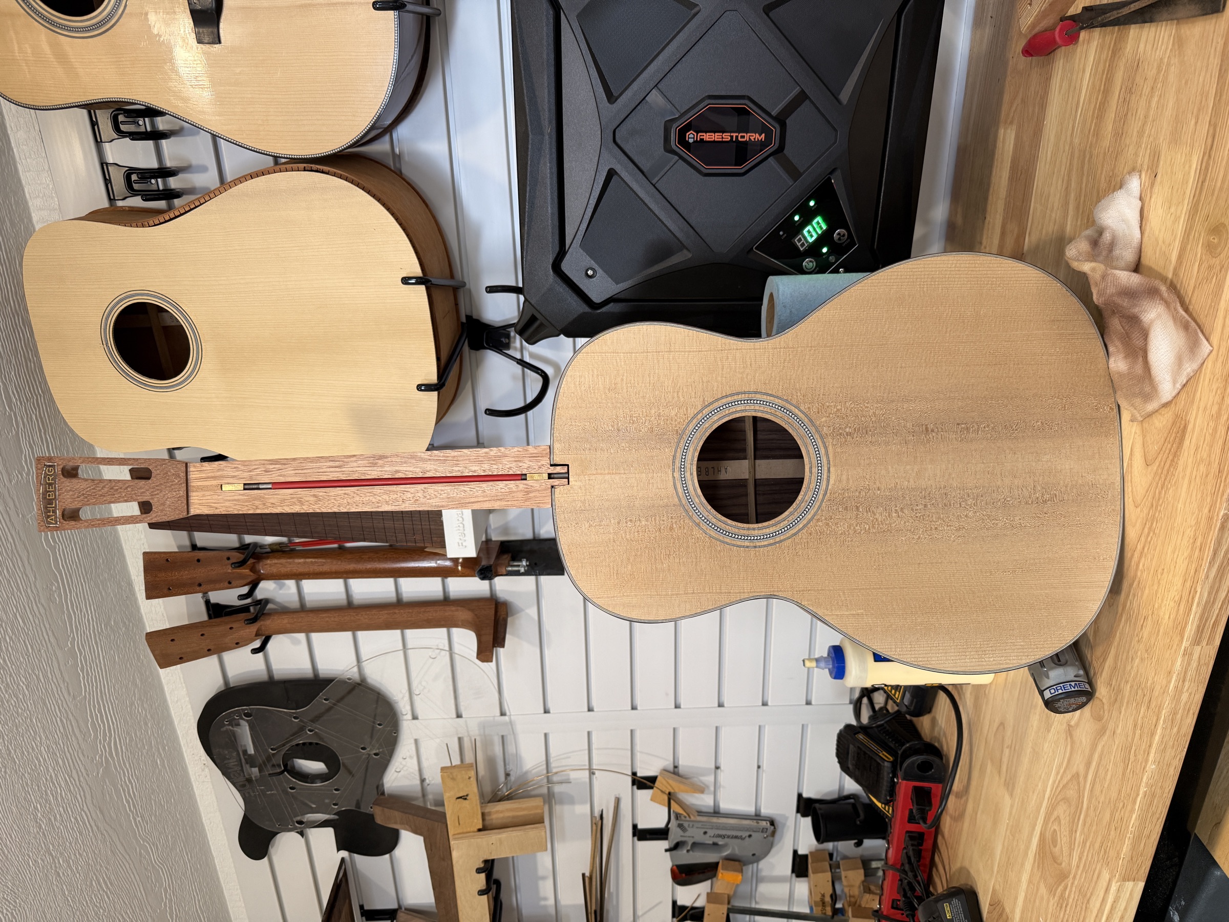 A nearly-finished acoustic body and matching neck blank on the workshop bench.